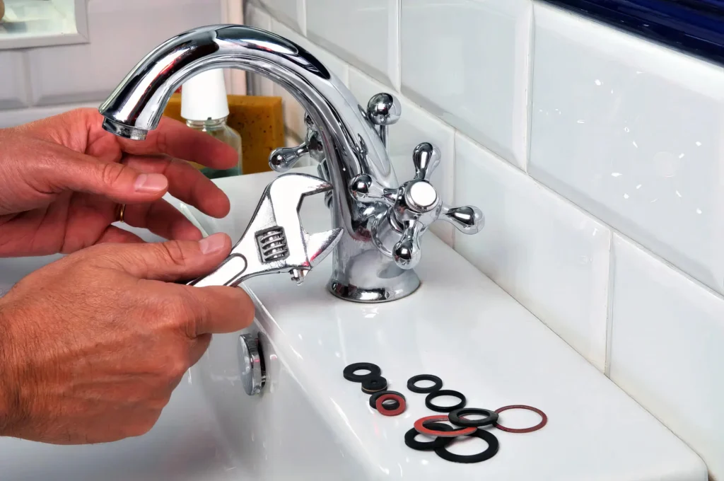 Plumber performing maintenance on a bathroom faucet in Castle Rock