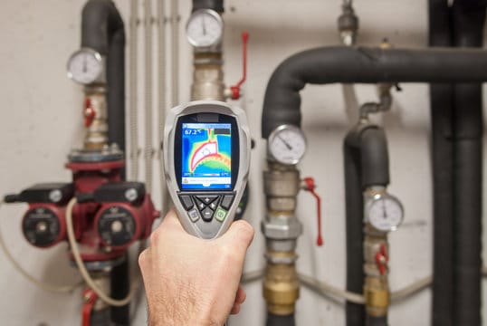 Plumber using a thermal imaging camera to inspect pipes in Castle Rock