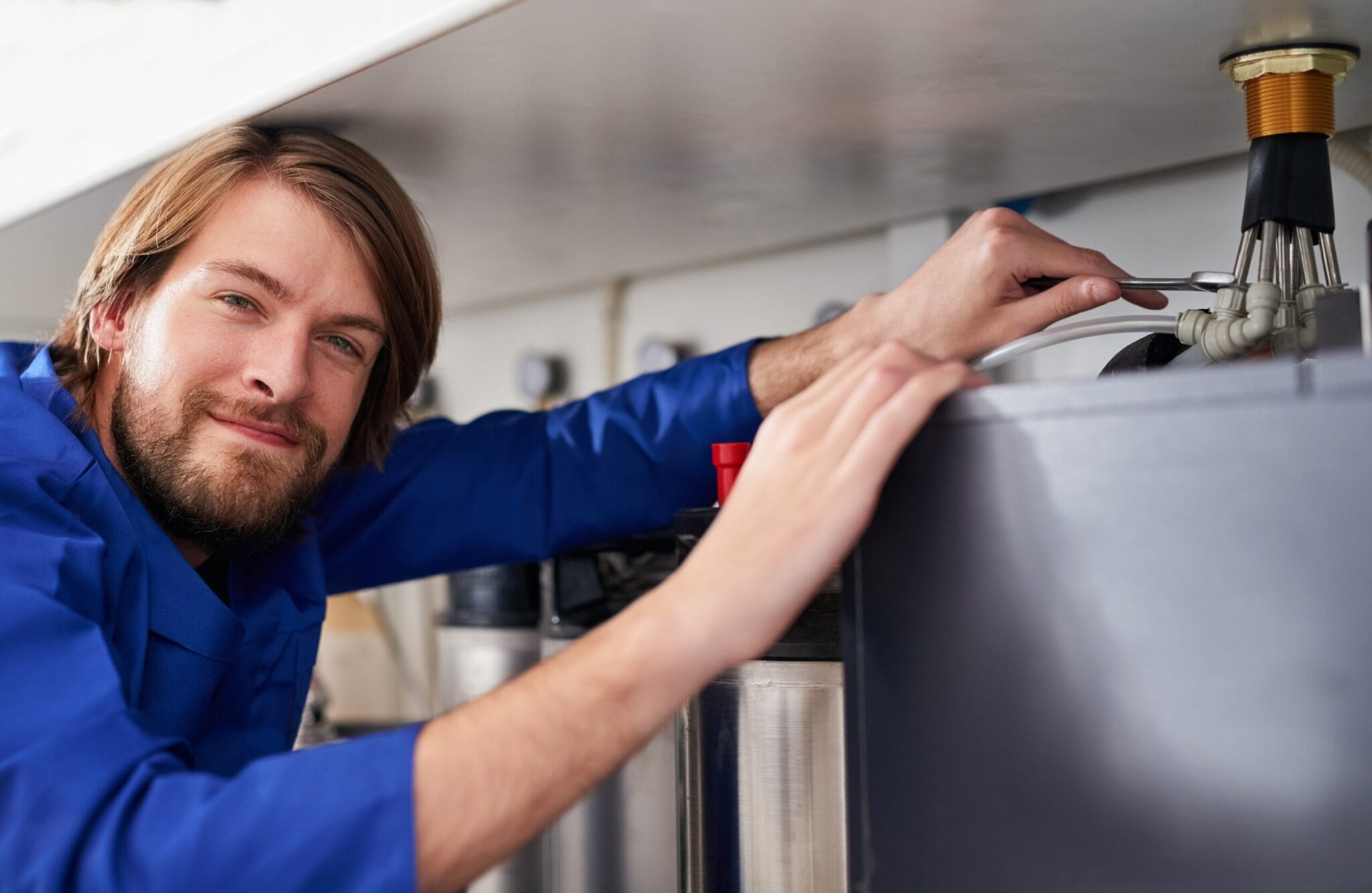 Technician servicing a residential water heater tank in Castle Rock